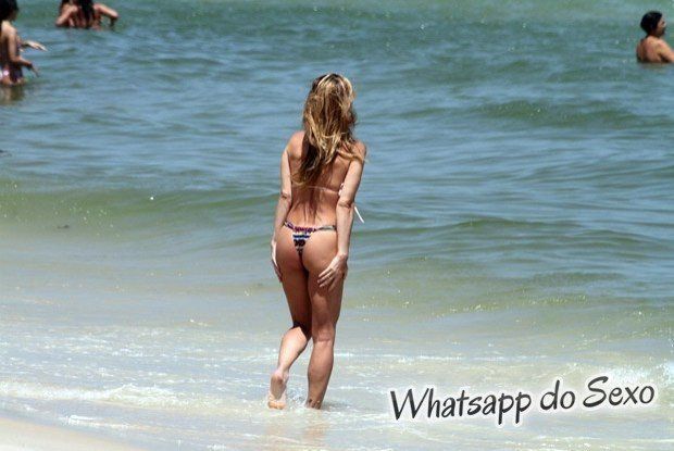 Danielle Winits pagando peitinho com biquíni transparente na praia